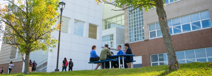 Students take a break outside the Center for the Arts near Lake LaSalle. 
