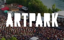 ARTPARK text logo in white, over aeriel view of the venue's outdoor ampitheater. 