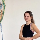 Headshot of Emma Akmakdjian, an interdisciplinary artist, wearing a black tank top. 