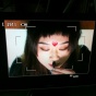 snapshot of the recording screen of a video camera with a woman's head in the frame. 