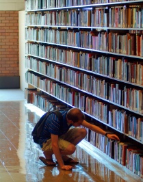 Student browsing library shelves. 