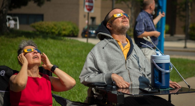 Two people observing a solar eclipse. 