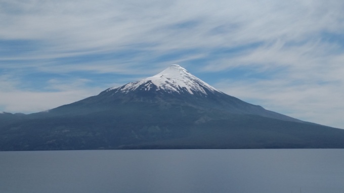 Osorno Volcano, huge volcano, topped with snow viewed across a body of water called Lago Llanquihue (Chile). 