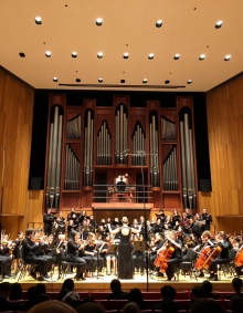 Orchestra performing on the stage at Slee Hall. 