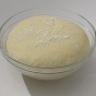 Dough rising in a clear glass bowl. 