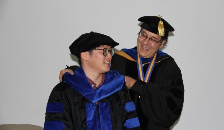 Hooding re-enactment without masks after the commencement ceremony. 