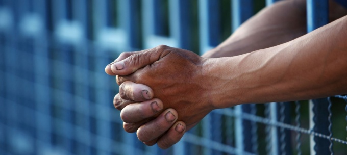 hands through jail cell bars. 