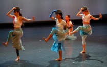 three dancers in blue dresses with fedoras. 