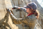 Kayla Hollister, UB geology master’s student, carefully removes a section of sediment from the wall of a mine. Credit: Elizabeth Thomas
