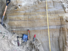 A shovel, tape measure and other tools are perched against the deposits of loess and ancient soil that form the wall of a mine. Layers of volcanic ash, also found in the wall, can help scientists determine the age of different sections of sediments. Credit: Elizabeth Thomas