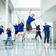 A group of ambassadors pose for a photo in matching blue shirts. 