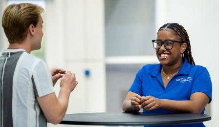 two students chatting and smiling. 