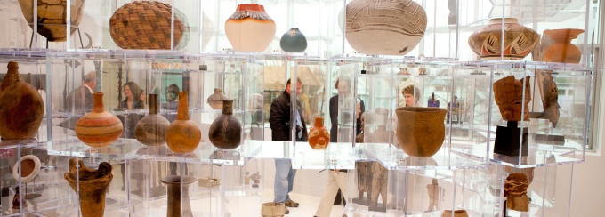 archeaological items from thousands of yeaers ago on display in compartments of a plexiglas storage and display wall. 