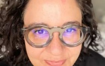 Headshot of Ilona Gaynor, wearing round wide-frame glasses. 