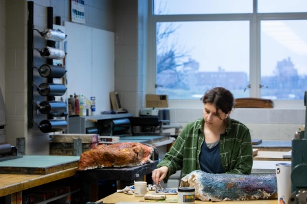 Zoom image: Taylor Robers, MFA 2023, working in printmaking lab in basement of the Center for the Arts. 