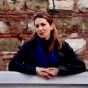 Berin Golonu with stone wall backdrop. 