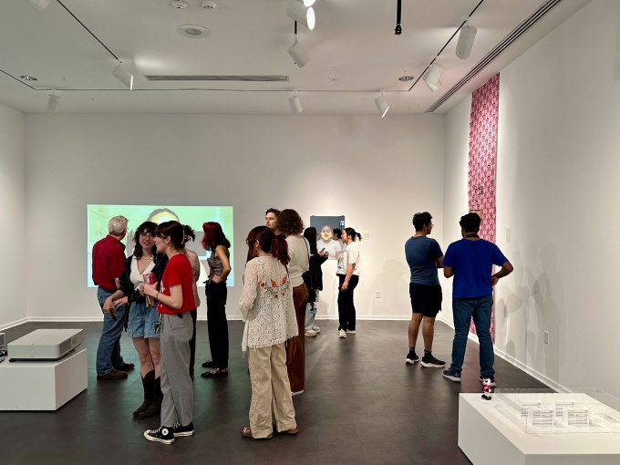 Zoom image: Guests visiting the BFA Senior Thesis group exhibition "Supreme", April 29th, 2024, in the Department of Art Lower Gallery, room B45 of the Center for the Arts.