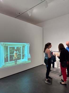Zoom image: Guests visiting the BFA Senior Thesis group exhibition "Supreme", April 29th, 2024, in the Department of Art Lower Gallery, room B45 of the Center for the Arts.