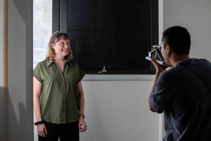 Zoom image: Student TJ Xu shooting a custom polaroid portrait, as part of the Student Art Sale. Image Credit: Meredith Forrest Kulwicki 