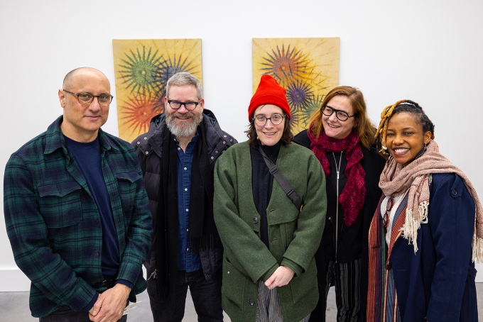 Zoom image: John Opera enjoys a visit from some UB colleagues during the opening reception. From left: Opera, Matt Kenyon, Becky Brown, Laura Chiesa and Victoria Udondian. 