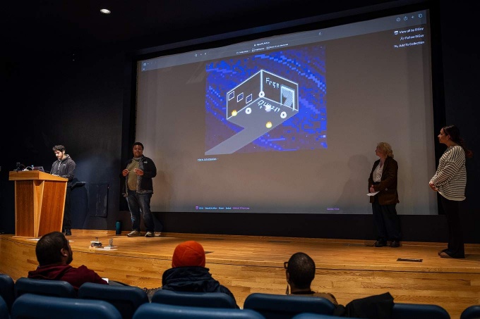 Students present a video game project on stage. 