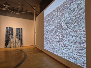 Zoom image: projection of wave art print on a white wall, with cyanotype printed strips on the rear wall