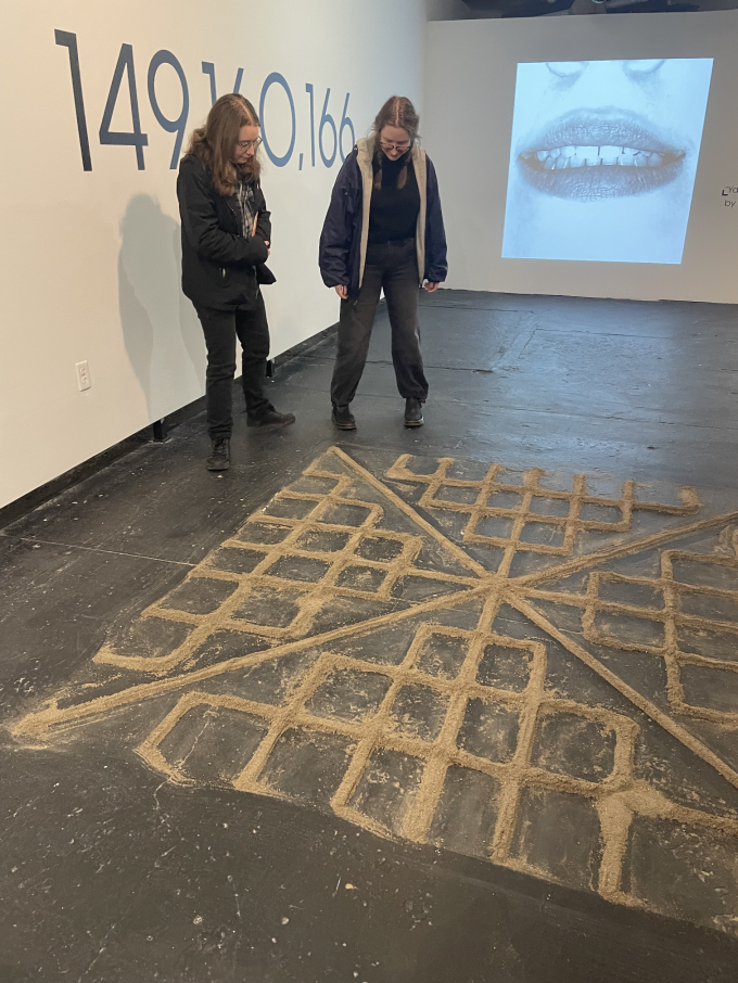 Zoom image: Viewers carefully walking around the perimeter of &ldquo;Urban Plates No.11&rdquo;, Video iteration of &ldquo;Yaşamaya Dair by N&acirc;zim Hikmet&rdquo; behind.&nbsp; 