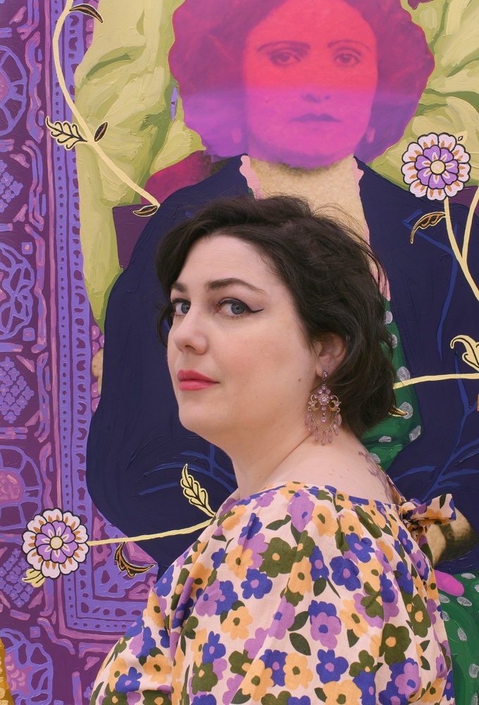 Headshot of artist Daisy Patton wearing and purple and yellow flowered dress in front of a multicolor portrait of a woman. 