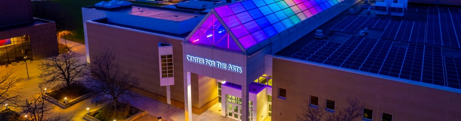 Aerial images taken at sunset of the Center for the Arts with rainbow lighting in the atrium glass to show support for UB’s LGBTQ + community in April 2023. 