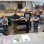 Students participating in a critique of work in the print lab. 