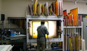 Screen printing spry booth with person cleaning screen. 