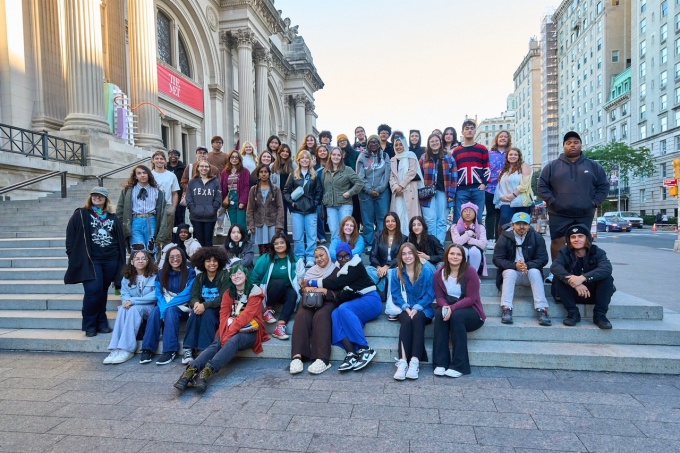 Picture of approximately 50 people on the stone steps outside the Metropolitan Museum of Art in New York City. 