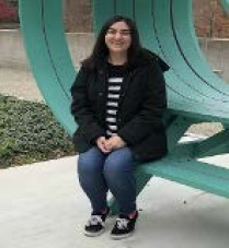 Student Ana Ruiz sitting on a bench. 