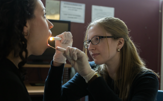 An evaluator looking into a client's mouth. 