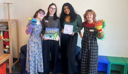 UB SLP Students featured left to right: Marissa Belmonte, Annie Jarvis, Drishti Chudasama, and Moira Griffin posing with hand puppets, children&rsquo;s book, and therapy timer at Buffalo Promise Neighborhood Children&rsquo;s Academy. 