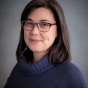Professional portrait of Dr. Castro smiling against a gray background. 