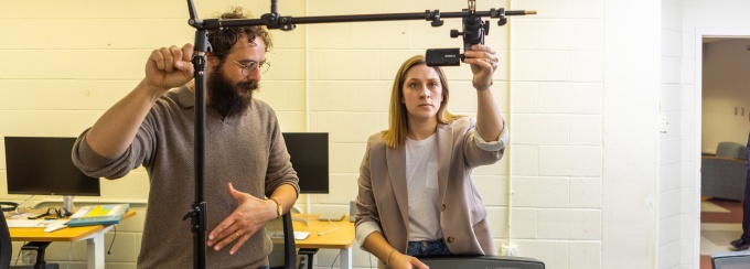 Graduate students set up video equipment to track their research in a lab. 