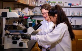 Professor G. Ekin Atilla-Gokcumen adjusting a sample with graduate student. 