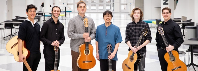 Six guitar players pose in the artirum of the Center for the Arts. 
