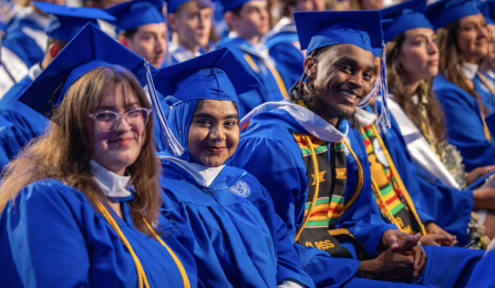 Students sitting for commencement and wearing regalia. 
