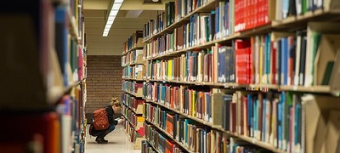 Student browsing stacks in the library. 