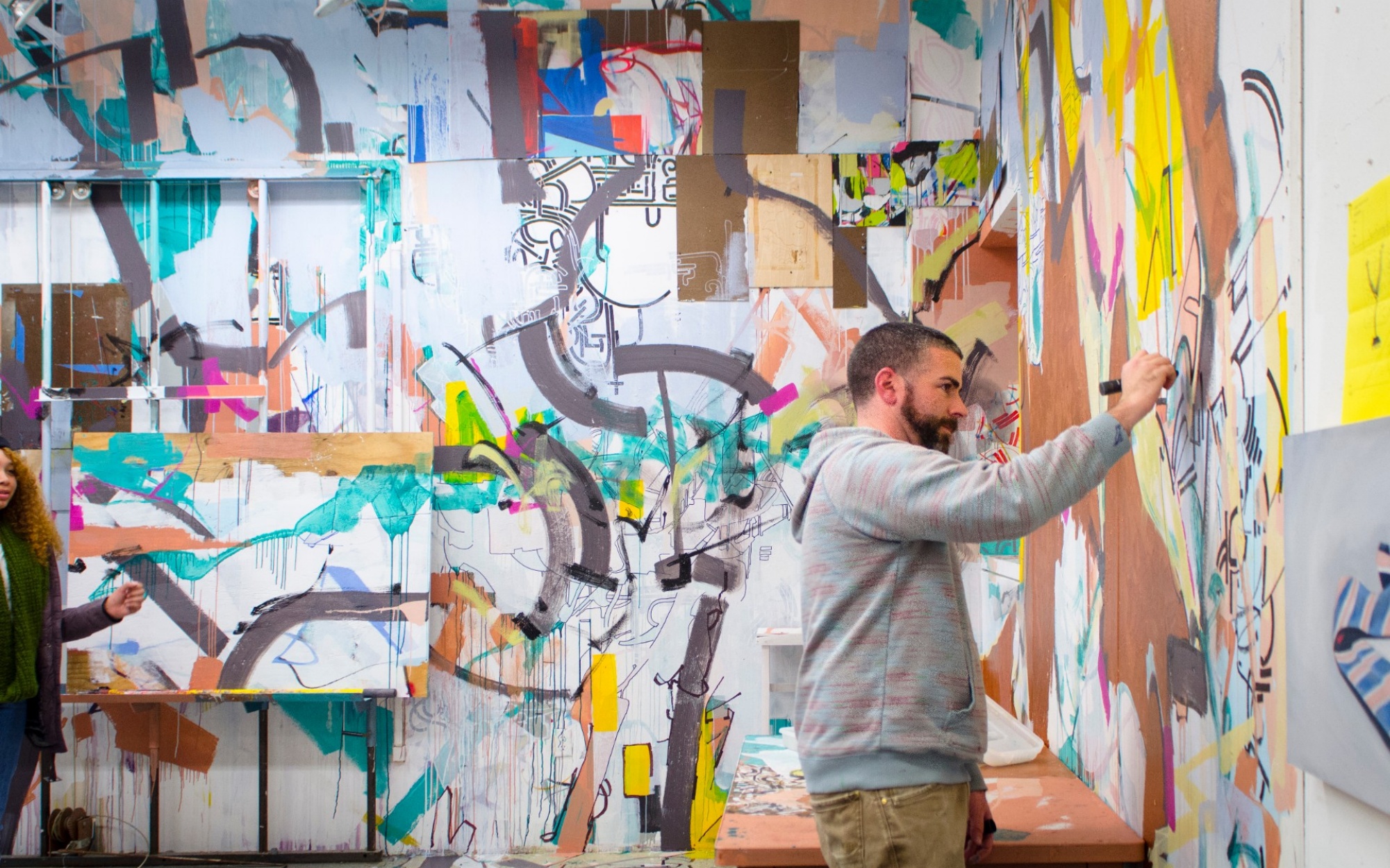 Student in art studio working on a mural. 