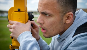 A student surveys out in the field. 