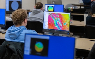 Student working looking at a volcano map at a computer. 