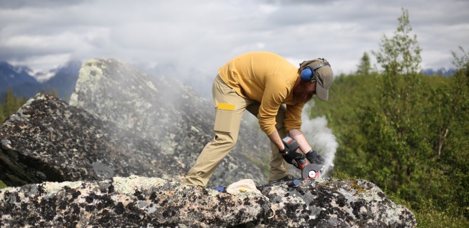 A student collects rock samples in the field. 