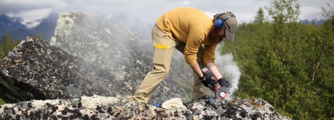 A student collects rock samples in the field. 