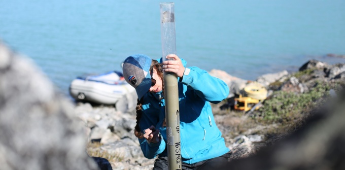 A student takes measurements out in the field. 