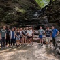 A group of students pose for a photo with Chestnut Ridge Park's eternal flame. 