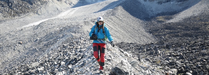 A student walking on a mountain ridge. 