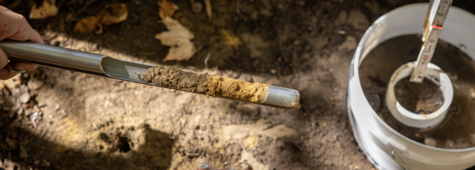 Students taking soil samples with a soil core probe. 